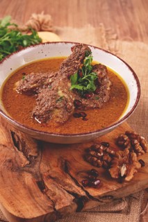 Fesenjan, an Iranian dish, stewed chicken, in a nut-pomegranate sauce, in a bowl, homemade, no