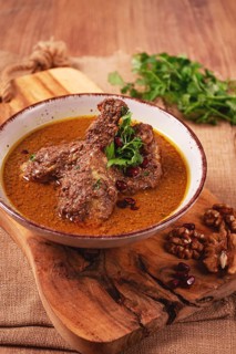 Fesenjan, an Iranian dish, stewed chicken, in a nut-pomegranate sauce, in a bowl, homemade, no