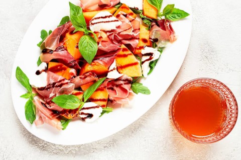 Salad with prosciutto and melon, with arugula and cheese, with balsamic sauce, natural light