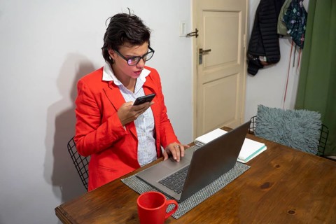 Modern professional having a phone meeting while working on a laptop