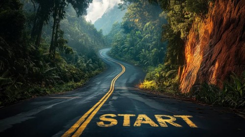 A winding road with 'start' painted on it leads through a lush forest, symbolizing new beginnings
