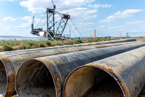Large excavator in open-cast mine with pipes in the foreground, Manheim, North Rhine-Westphalia,