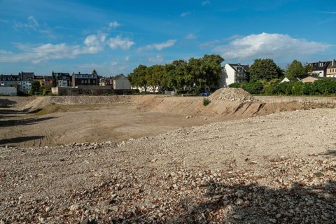 Excavation pit with houses in the background, Ehrenfeld, Cologne, North Rhine-Westphalia, Germany