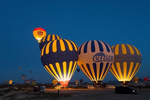 Several illuminated hot-air balloons decorate the sky at dawn, Göreme National Park, Göreme Tarihî