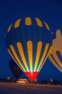 Various hot air balloons are prepared at night and light up the landscape, Göreme National Park,