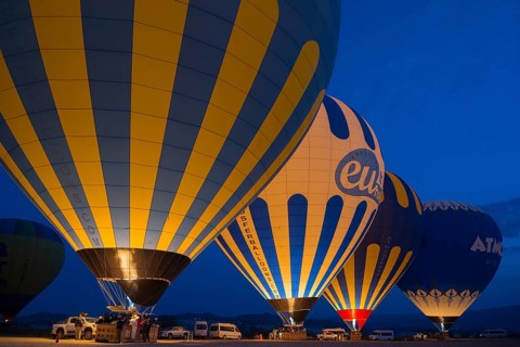 Hot air balloons glow in the dark with colourful lights, Göreme National Park, Göreme Tarihî Millî