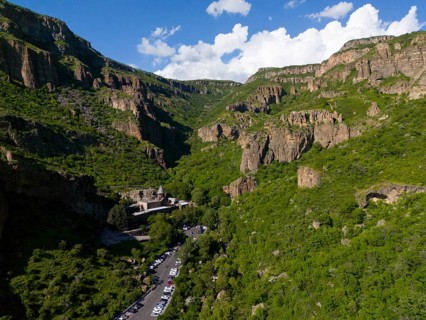 Valley with dense forest and a road leading through the scenery, aerial view, Geghard Monastery,