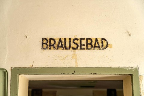 Shower bath inscription on a gas chamber, Dachau Concentration Camp Memorial, Bavaria, Germany