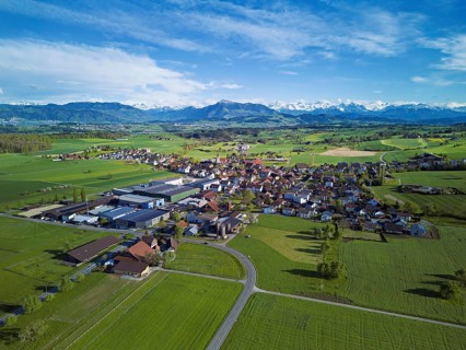 View of the village, in the foreground the industrial area, in the background the Rigi and the