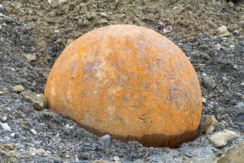 Rusty metal ball used for stone crushing in stony back