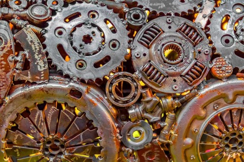 Full frame warm illuminated metallic mechanical background with gear wheels and other material