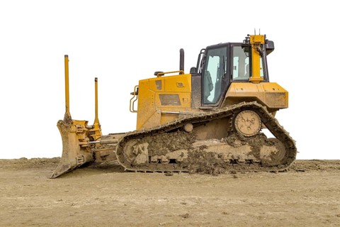 Yellow bulldozer at a loamy construction site, partly isolated in white back