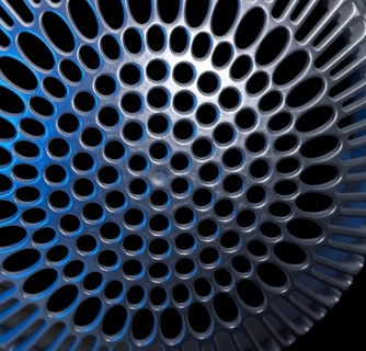 Abstract detail of a blue illuminated metallic cover in black back