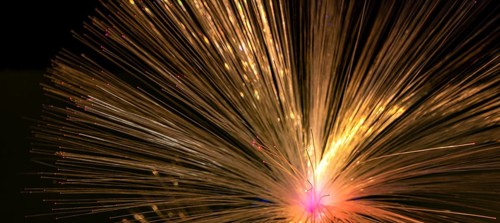 Illuminated fanned out optical fibers closeup in black back