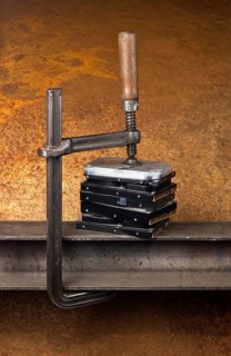 Some hard disk drives compressed with a screw clampin rusty back