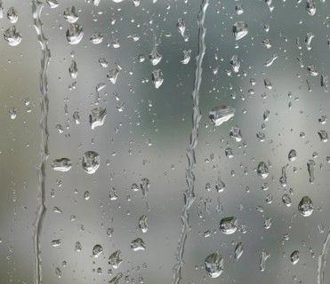 Detail of roll off raindrops on window glass