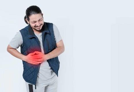 Man suffering with liver pain on isolated background. Young man with abdominal pain
