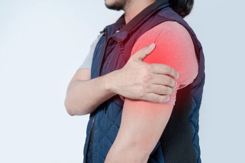 Unrecognizable person with shoulder pain on isolated. Person in pain with arm pain highlighted in