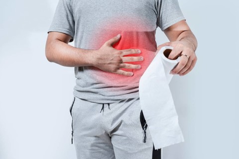 Person with digestive problems holding toilet paper isolated. Digestive disease concept