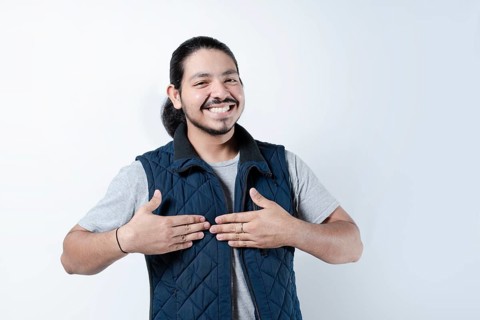 Smiling man with hands on chest on isolated background