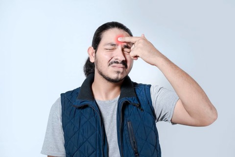 Young latino man with a headache on isolated. Male with migraine on white background