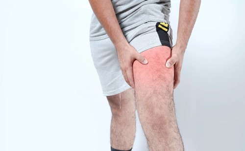 Closeup of sore knee on isolated background. Male holding his knee in pain on isolated
