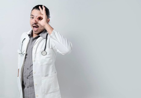 Doctor looking through his fingers. Young doctor with open mouth