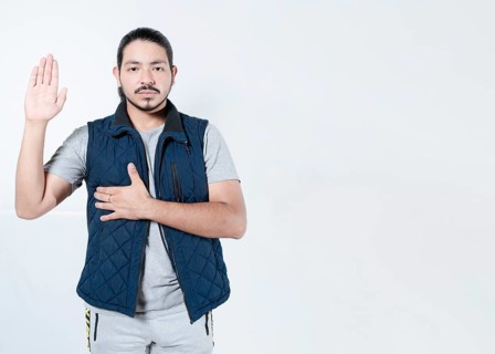 Serious man taking oath on isolated background. Young man taking an oath on white background