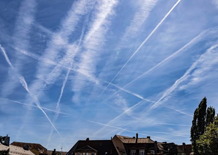 Contrails in the sky. These artificial clouds are created from the exhaust fumes of aeroplanes. But