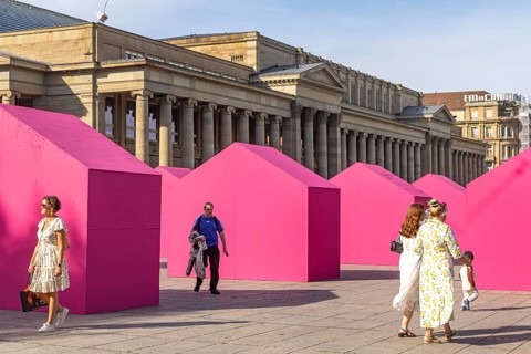 Twelve houses in bright magenta stand on Stuttgart's Schlossplatz in front of the art museum. The