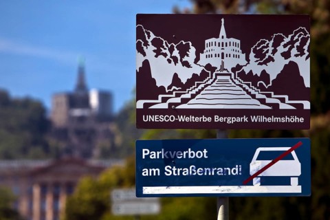 Bergpark Wilhelmshöhe, sharp sign with park prohibition notice and blurred Hercules building,