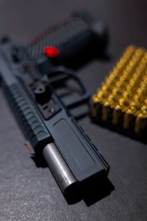 Modern Elegant Sport Handgun with Gas Pedal and Skirt and Bullet on Grey Background in Switzerland