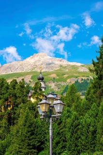 Church Tower and Street Lamp in the Forest and Mountain in the Swiss Alps in a Sunny Summer Day in