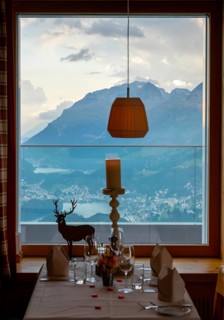 Beautiful Restaurant Table Window View over Alpine Lake and Swiss Alps and Cityscape in Sunset and