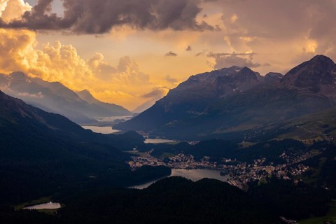 Beautiful Aerial View over Five Lakes and Swiss Alps and Cityscape in Sunset and Storm Clouds over
