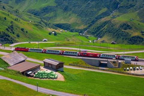 Beautiful View over Mountain Valley with Mountain Road and Railroad Station with Glacier Express