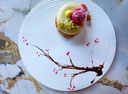 Elegant Dessert Creamy Pistachio Biscuit with Fresh Cream and Decorated with Raspberry and Chopped
