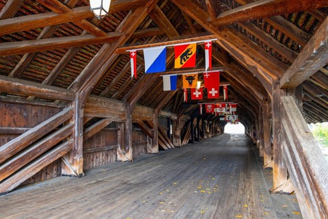 Inside the Old Historical Covered Wood Bridge Holzbrücke with Swiss Canton Flags over River Aare in