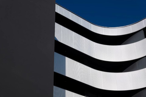 Beautiful Modern Concrete Design Building with Metal Balcony Against Blue Sky in Switzerland