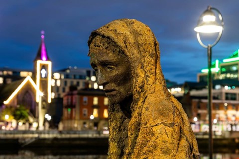 Sculpture of a starving person, Famine memorial, detail, night shot, Dublin, Ireland