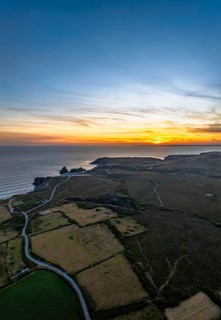 Sunset over Kynance Cove from a drone, Mount's Bay, Lizard Point, Cornwall, England, United Kingdom
