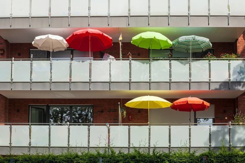 Balconies with colourful parasols on a modern residential building, Bremerhaven, Bremen, Germany
