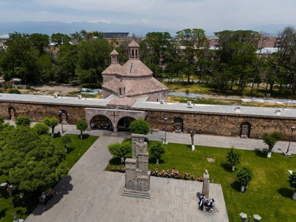 Historic church and monument in a green park with people in an urban setting, aerial view, St
