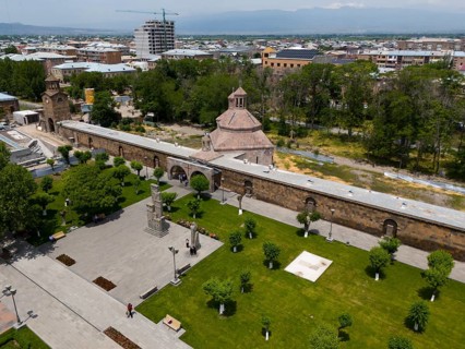 Historical monastery complex in the middle of a green park with city view and mountains in the