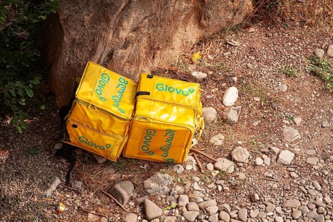 08/25/2025 Georgia, Tbilisi, Delivery packages, Glovo company, left on stony ground, near bushes,