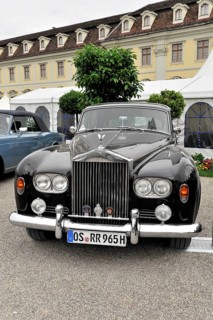 A black classic Rolls-Royce vintage car parked in front of a historic building, Retro Classics