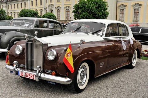 Two-coloured brown and white Rolls-Royce vintage car decorated with flags for a parade, Retro