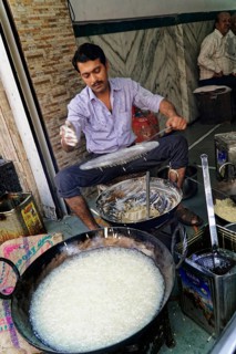 Udaipur, Rajasthan, North India, Asia, Man cooking a traditional dish on the street with pans and