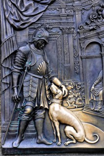 Tourists touch a plaque that is part of the statue of St John of Nepomuk and is supposed to bring