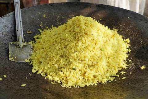 Kota, Rajasthan, North India, Asia, A large pile of poha in an iron pan with a spatula next to it,
